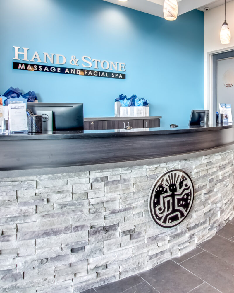Light blue walls behind the front desk inside a hand and stone spa